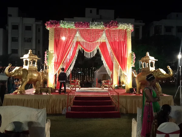 Wedding decoration: Red & white drapes; chandeliers; plush central seating